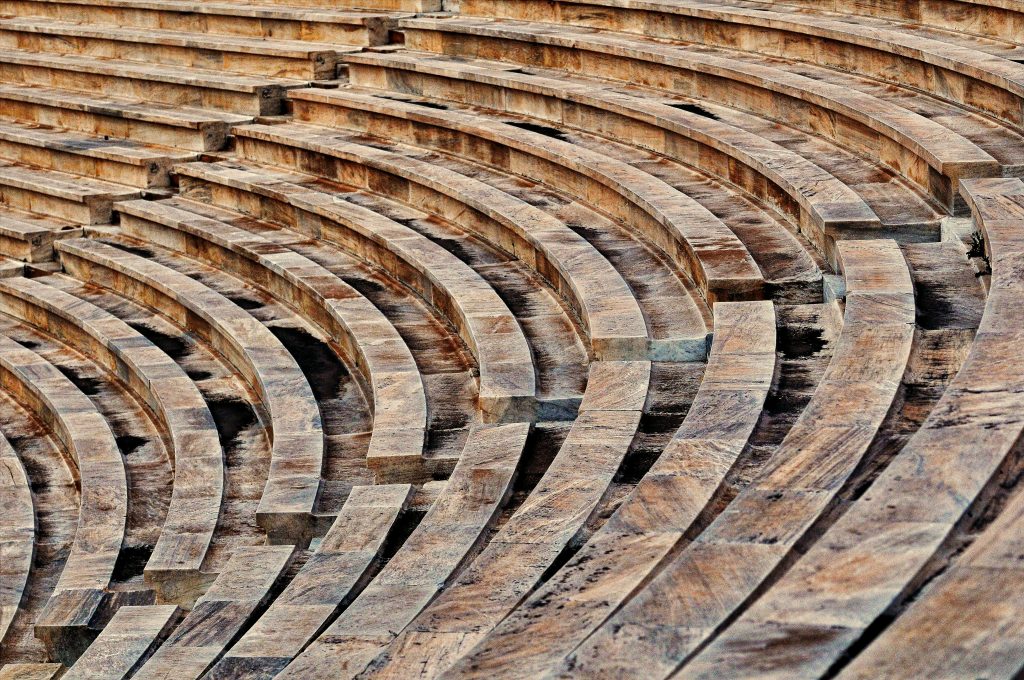 Close-up of weathered stone seating in an ancient amphitheater, showcasing curved architecture and patterns.